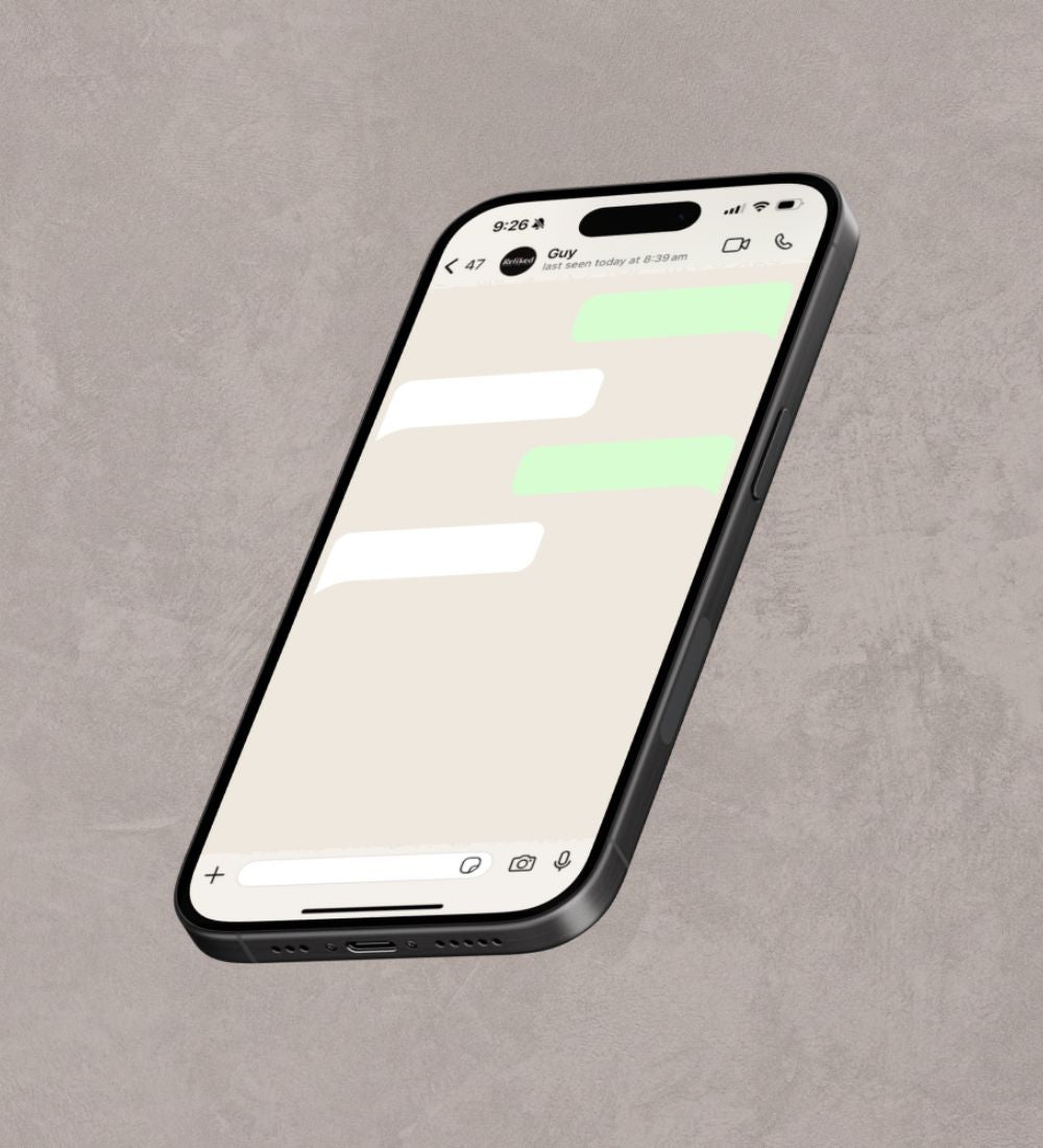 Smartphone on a gray surface with a messaging app open on the screen