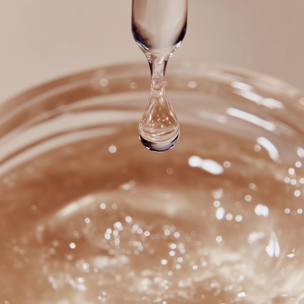 Close-up of a droplet falling into water with ripples.